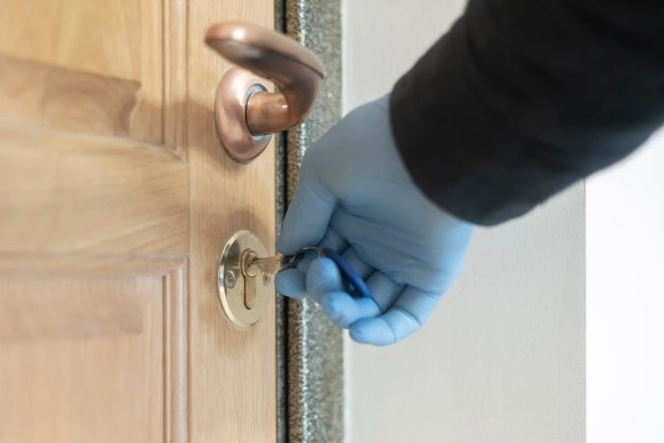 Mannen reparerer låsesmeden, setter dørlåsen på tredøren