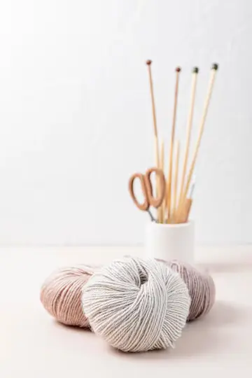 strikkepinner med garn i naturlige farger